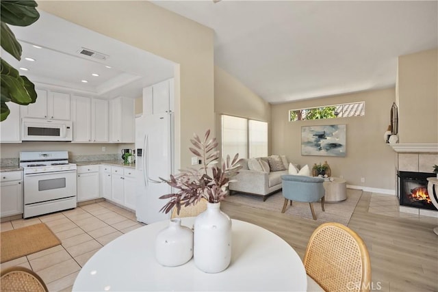 20 Via Jolitas, Rancho Santa Margarita, CA 92688 - kitchen featuring white appliances, open floor plan, white cabinets, a tile fireplace, and light wood-style floors