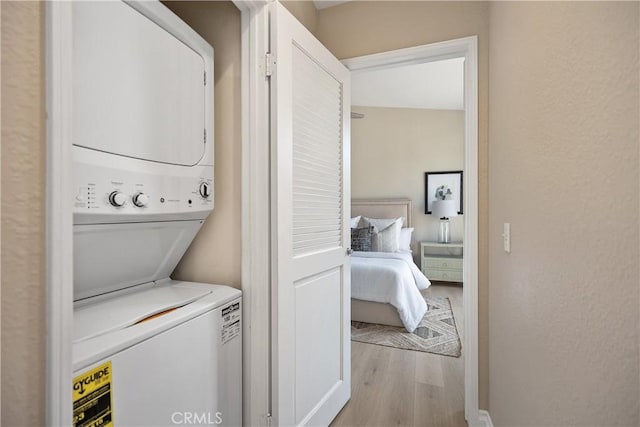 20 Via Jolitas, Rancho Santa Margarita, CA 92688 - washroom featuring stacked washer and clothes dryer, wood finished floors, and a textured wall