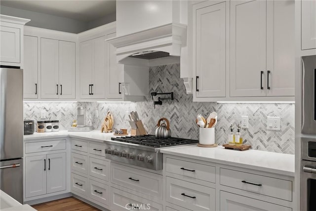 212 Valley View Dr, Paradise, CA 95969 - kitchen with stainless steel appliances, white cabinetry, backsplash, light countertops, and custom range hood