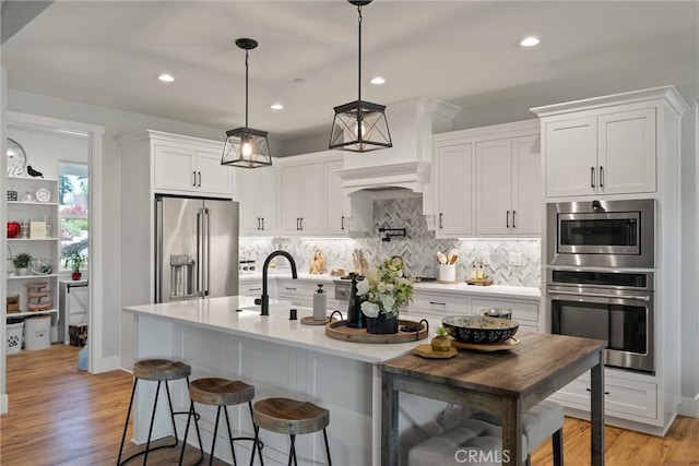 212 Valley View Dr, Paradise, CA 95969 - kitchen with appliances with stainless steel finishes, decorative backsplash, white cabinetry, light countertops, and light wood-style flooring