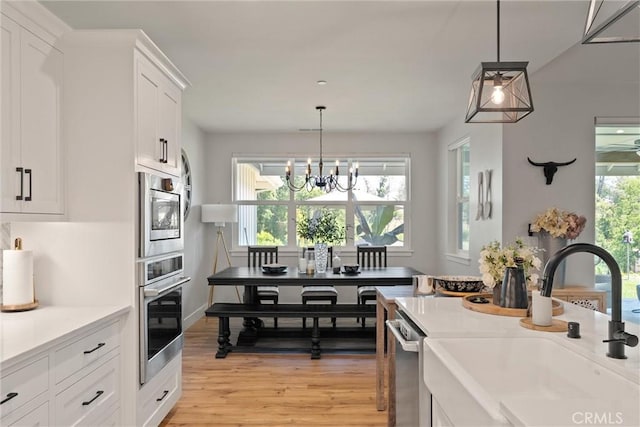 212 Valley View Dr, Paradise, CA 95969 - kitchen featuring appliances with stainless steel finishes, white cabinetry, light countertops, light wood-style floors, and a chandelier