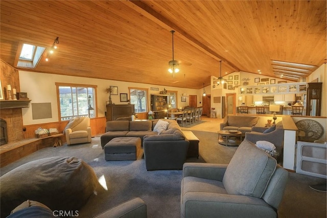 32383 Pine Manor Ln Unit 634, Running Springs, CA 92382 - carpeted living area featuring vaulted ceiling, wainscoting, wooden ceiling, a skylight, and a fireplace