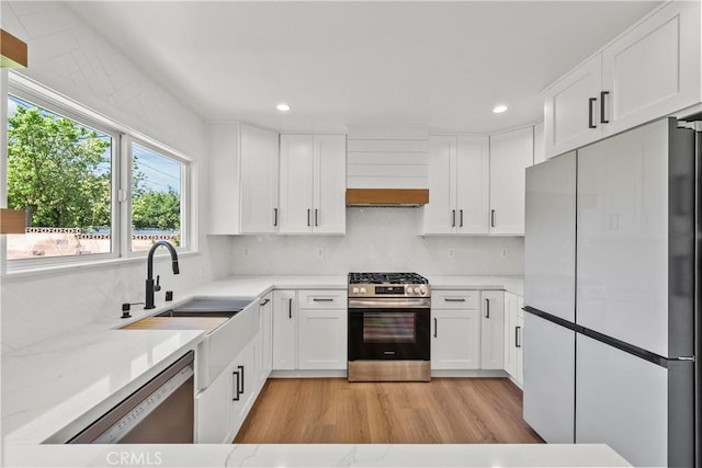 19548 Cedarcreek St, Canyon Country, CA 91351 - kitchen with appliances with stainless steel finishes, light wood-style floors, backsplash, white cabinets, and recessed lighting