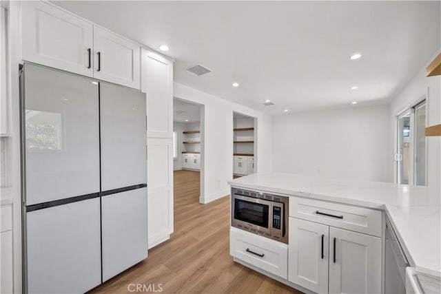 19548 Cedarcreek St, Canyon Country, CA 91351 - kitchen featuring freestanding refrigerator, stainless steel microwave, light wood-type flooring, white cabinets, and recessed lighting
