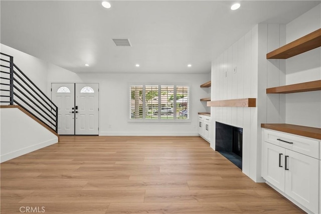 19548 Cedarcreek St, Canyon Country, CA 91351 - unfurnished living room featuring stairway, a large fireplace, light wood-style flooring, and recessed lighting