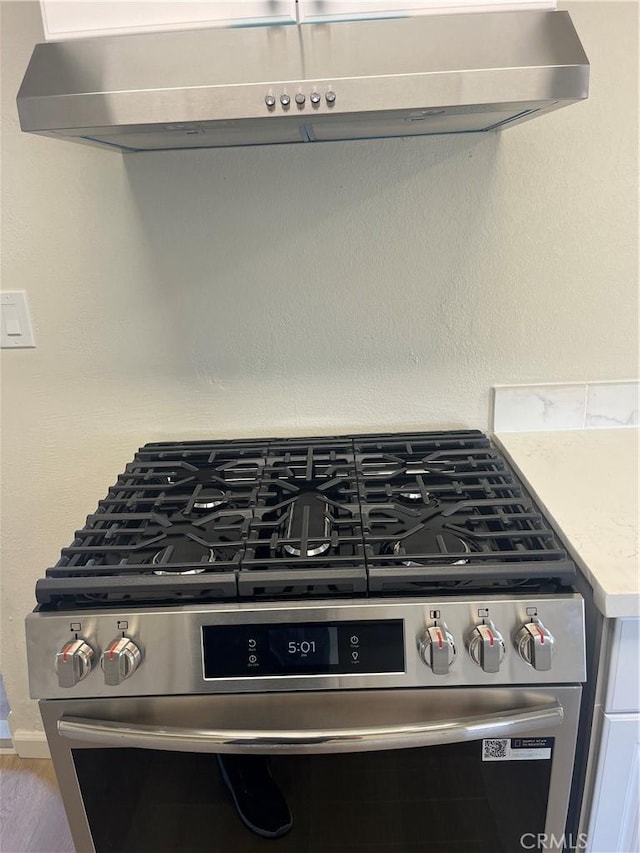 1231 Webster St, Redlands, CA 92374 - detailed view of stainless steel gas stove, under cabinet range hood, and light countertops