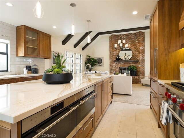502 Washington St, El Segundo, CA 90245 - kitchen with brown cabinetry, plenty of natural light, a brick fireplace, open floor plan, and recessed lighting