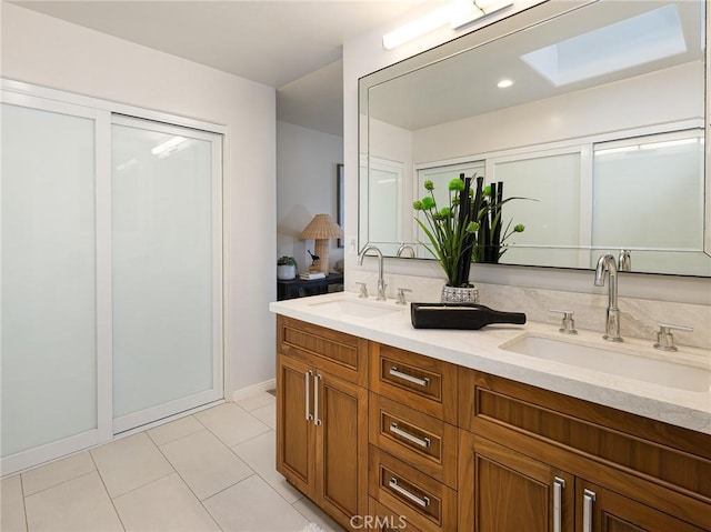 502 Washington St, El Segundo, CA 90245 - bathroom with double vanity, tile patterned flooring, and a skylight