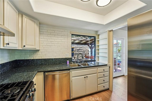 750 Via Los Santos, San Dimas, CA 91773 - kitchen featuring stainless steel appliances, light wood-type flooring, dark countertops, and a tray ceiling