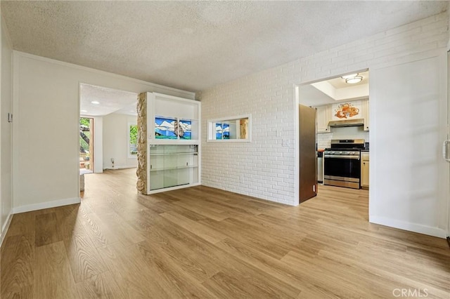 750 Via Los Santos, San Dimas, CA 91773 - unfurnished living room featuring a textured ceiling, light wood-style floors, and brick wall