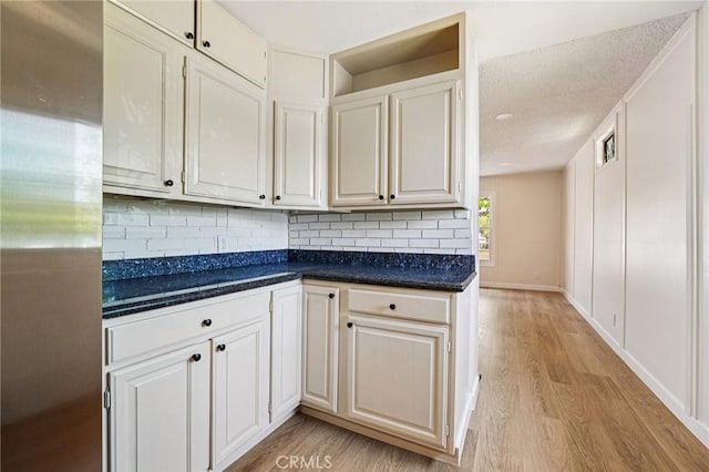 750 Via Los Santos, San Dimas, CA 91773 - kitchen with light wood finished floors, tasteful backsplash, dark countertops, and white cabinetry