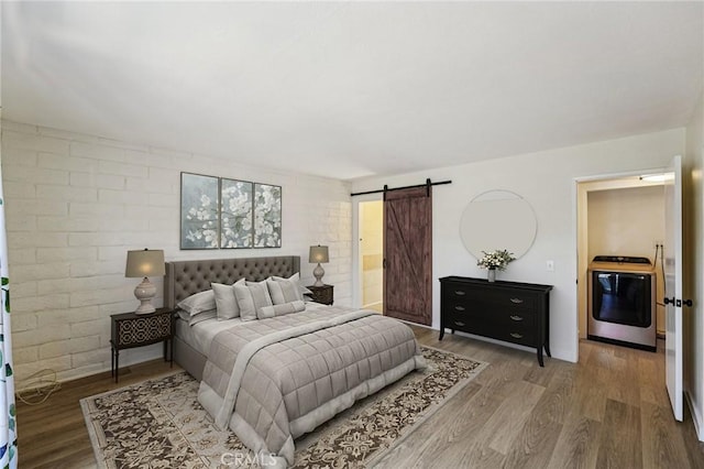 750 Via Los Santos, San Dimas, CA 91773 - bedroom featuring washer / clothes dryer, a barn door, and wood finished floors