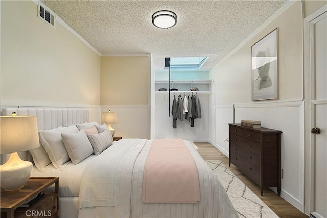 750 Via Los Santos, San Dimas, CA 91773 - bedroom featuring a textured ceiling, a closet, wood finished floors, ornamental molding, and a skylight