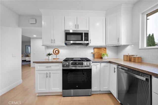 644 Kenoak Dr, Placentia, CA 92870 - kitchen with appliances with stainless steel finishes, white cabinets, decorative backsplash, and light wood finished floors