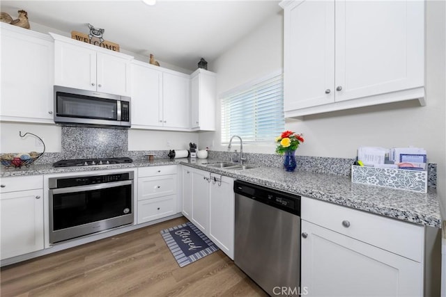 10757 Morgan Ct, Hesperia, CA 92345 - kitchen featuring appliances with stainless steel finishes, white cabinets, light wood-style flooring, and light stone counters