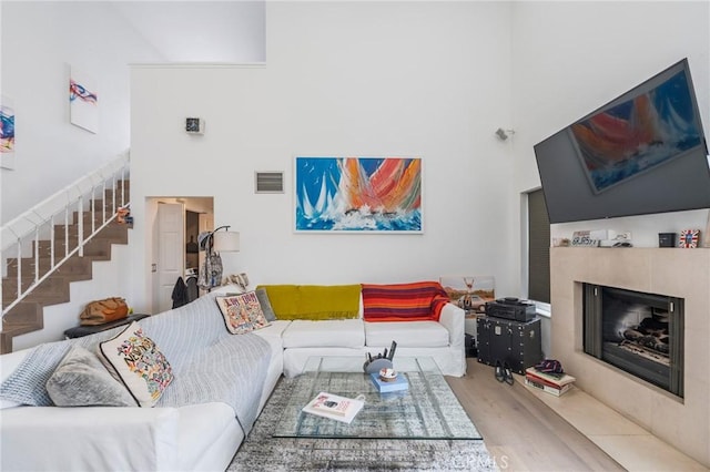 432 S Hamel Rd Unit 302, Los Angeles, CA 90048 - living area featuring stairway, a fireplace, a high ceiling, and wood finished floors