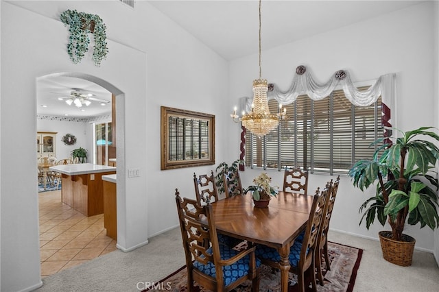 20865 Westbury Rd, Riverside, CA 92508 - dining area featuring a chandelier, ceiling fan, arched walkways, light colored carpet, and light tile patterned flooring