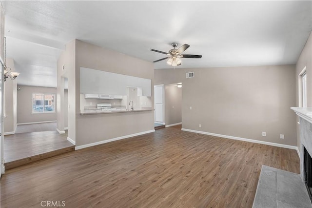 4633 Dowel Ave, Palmdale, CA 93552 - unfurnished living room featuring ceiling fan, wood finished floors, and a tiled fireplace