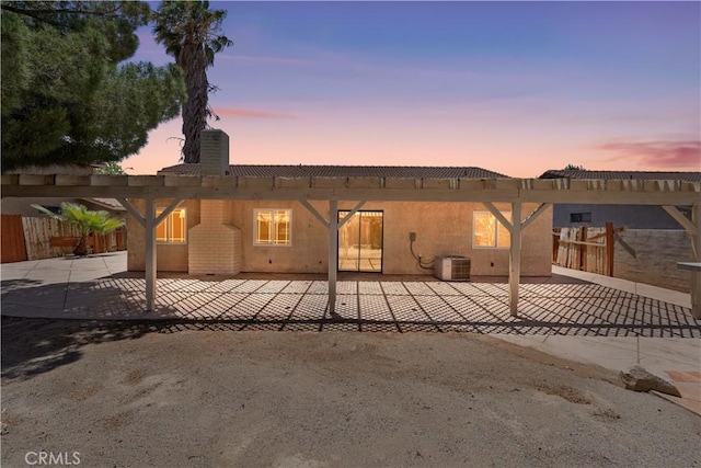 4633 Dowel Ave, Palmdale, CA 93552 - back of property at dusk with a chimney, a patio area, stucco siding, and a pergola