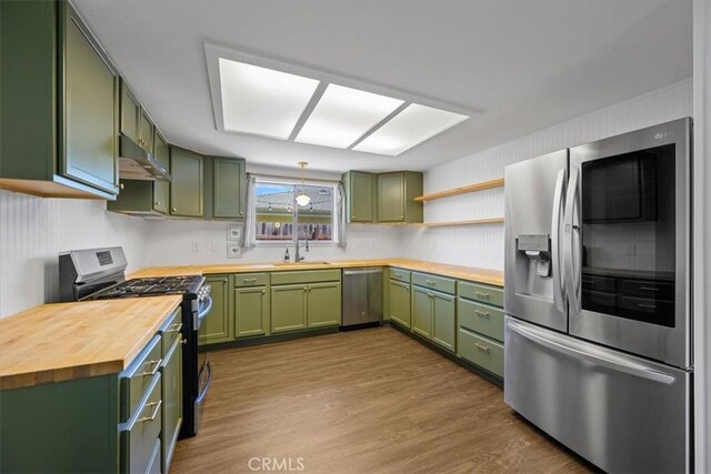 1066 Maple St, Arroyo Grande, CA 93420 - kitchen featuring appliances with stainless steel finishes, green cabinetry, butcher block countertops, under cabinet range hood, and dark wood-style floors