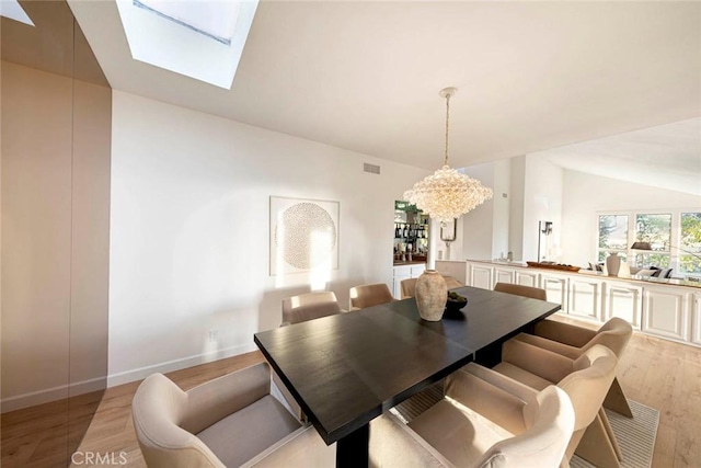 11 Montpellier Unit 22, Newport Beach, CA 92660 - dining area featuring light wood-type flooring, a chandelier, a skylight, and vaulted ceiling