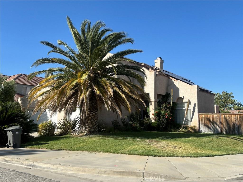 38830 Calistoga St, Palmdale, CA 93551 - view of home's exterior featuring stucco siding and a chimney