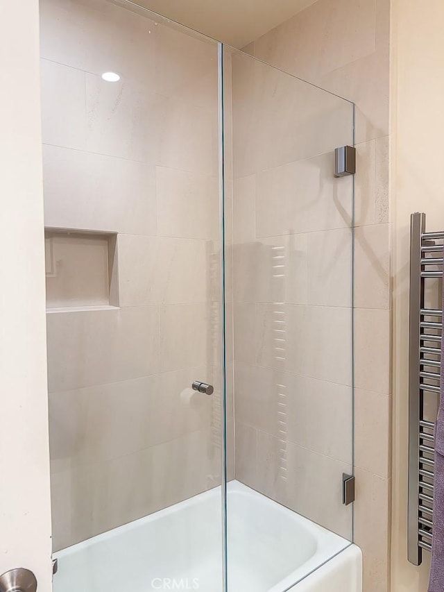 557 Lucerne St, Cayucos, CA 93430 - full bathroom with radiator heating unit, combined bath / shower with glass door, and a towel warmer