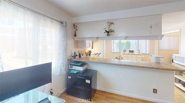 21602 Figueroa St Unit 25, Carson, CA 90745 - kitchen with white appliances, light wood-style floors, a peninsula, and light stone counters