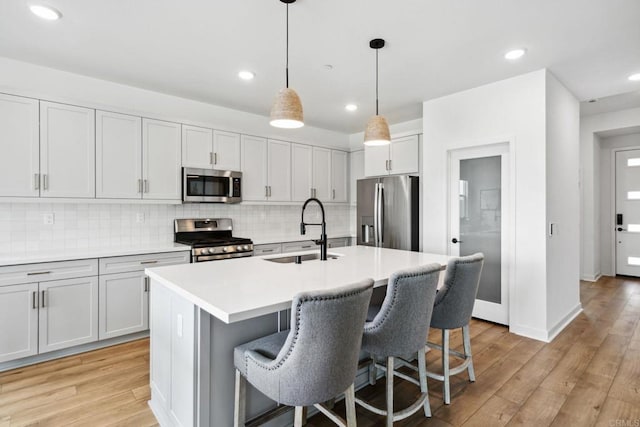35188 Orchard Trl, Fallbrook, CA 92028 - kitchen featuring appliances with stainless steel finishes, a breakfast bar, decorative backsplash, a kitchen island with sink, and recessed lighting