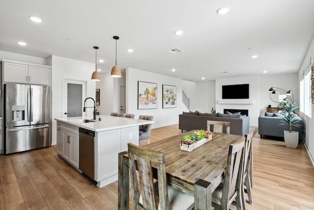 35188 Orchard Trl, Fallbrook, CA 92028 - dining space featuring a fireplace, wood finished floors, recessed lighting, and stairs