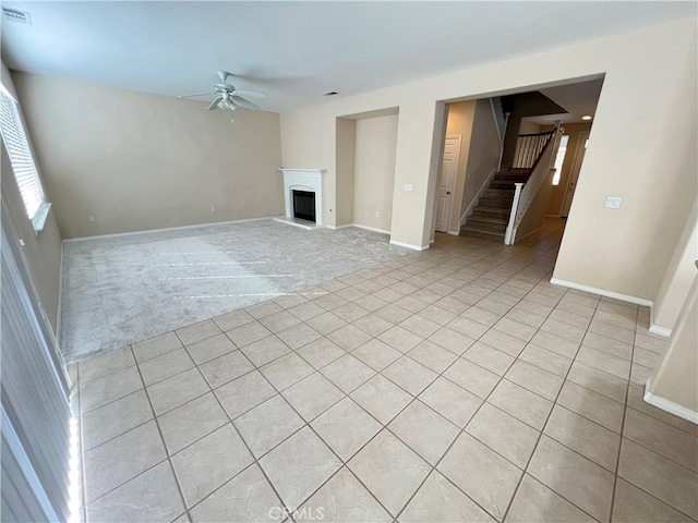 3642 Neola Way, Lancaster, CA 93536 - unfurnished living room with ceiling fan, stairway, light carpet, a fireplace with raised hearth, and light tile patterned floors