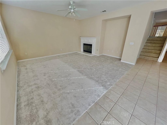 3642 Neola Way, Lancaster, CA 93536 - unfurnished living room with carpet, a ceiling fan, stairway, tile patterned floors, and a glass covered fireplace