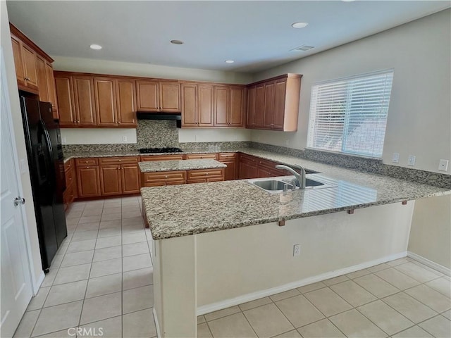 3642 Neola Way, Lancaster, CA 93536 - kitchen with black appliances, a peninsula, light tile patterned floors, light stone counters, and a breakfast bar area