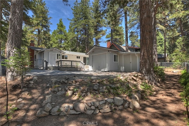 31449 Onacrest Dr, Running Springs, CA 92382 - view of side of home with a chimney, an attached garage, a deck, and board and batten siding
