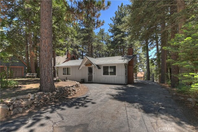 31449 Onacrest Dr, Running Springs, CA 92382 - view of front facade with a chimney, asphalt driveway, and board and batten siding