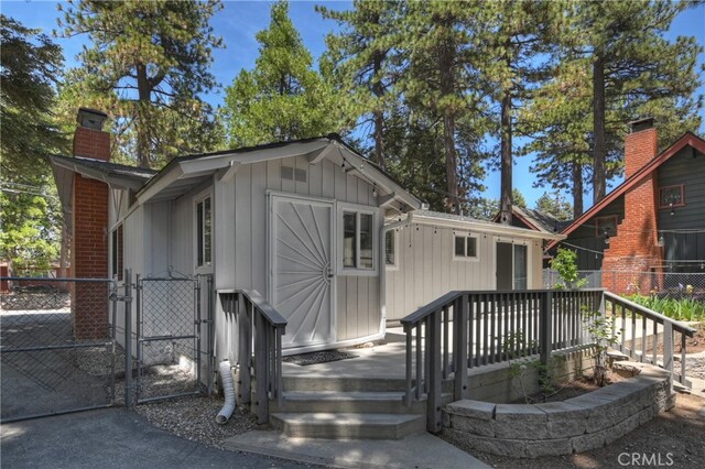 31449 Onacrest Dr, Running Springs, CA 92382 - view of front of property with a gate, a chimney, and board and batten siding