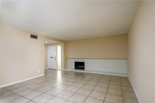 1881 Mitchell Ave Unit 8, Tustin, CA 92780 - unfurnished living room with a textured ceiling, a brick fireplace, and light tile patterned floors
