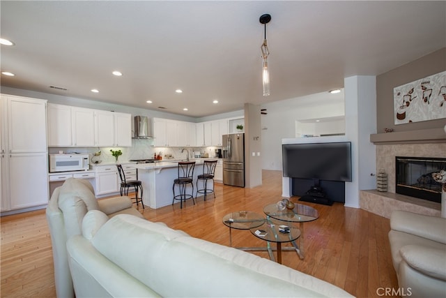 29427 Bentcreek Ct, Menifee, CA 92584 - living area featuring light wood-style flooring, recessed lighting, and a tiled fireplace