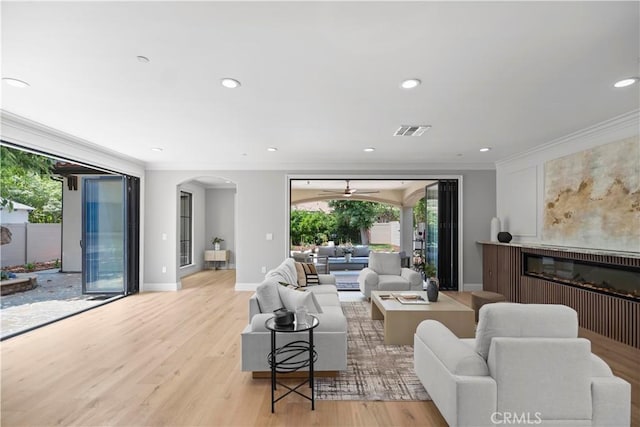 1935 S 6th Ave, Arcadia, CA 91006 - living area with a glass covered fireplace, arched walkways, crown molding, light wood finished floors, and recessed lighting