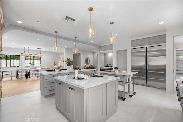 1935 S 6th Ave, Arcadia, CA 91006 - kitchen with gray cabinetry, a large island with sink, built in refrigerator, recessed lighting, and light stone countertops