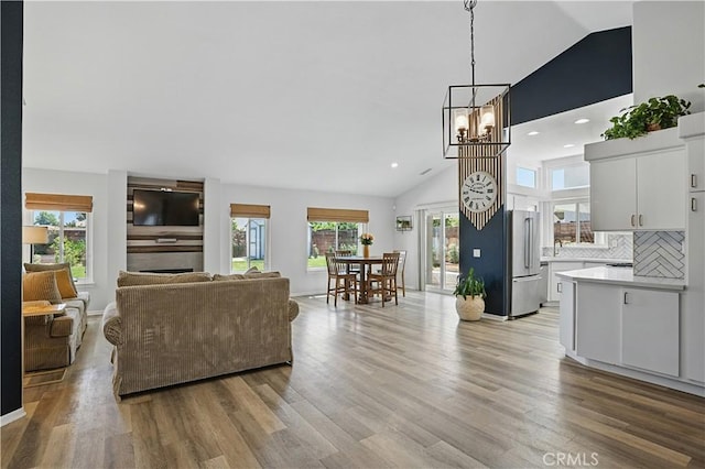 28591 Corvus Way, Menifee, CA 92586 - living area featuring light wood finished floors, a chandelier, recessed lighting, and high vaulted ceiling