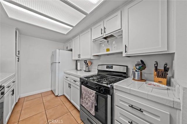 430 Anderwood Ct Unit 24, Pomona, CA 91768 - kitchen featuring stainless steel range with gas cooktop, freestanding refrigerator, open shelves, white cabinets, and tile counters