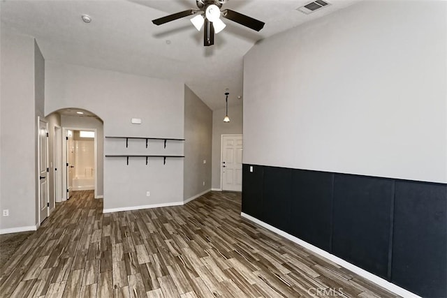 12745 Autumn Leaves Ave, Victorville, CA 92395 - empty room featuring a ceiling fan, wood finished floors, arched walkways, and vaulted ceiling