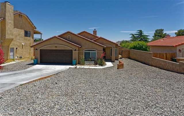 12745 Autumn Leaves Ave, Victorville, CA 92395 - mediterranean / spanish house featuring a garage, driveway, a chimney, and stucco siding