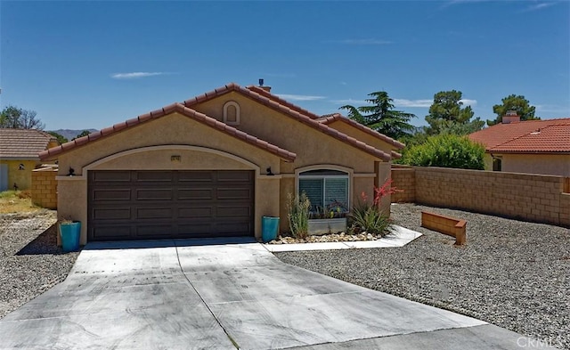 12745 Autumn Leaves Ave, Victorville, CA 92395 - mediterranean / spanish home featuring a garage, concrete driveway, stucco siding, and a tile roof