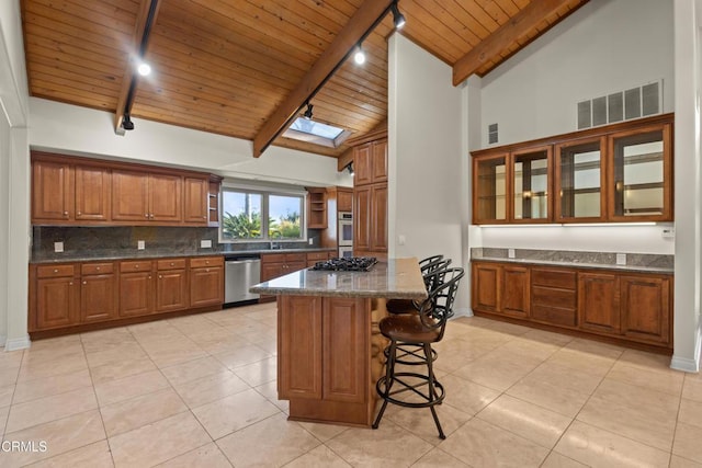 590 Alosta Dr, Camarillo, CA 93010 - kitchen with appliances with stainless steel finishes, a wooden ceiling with exposed beams, brown cabinetry, light tile patterned flooring, and tasteful backsplash