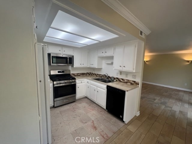 24321 El Pilar Unit 11, Laguna Niguel, CA 92677 - kitchen featuring stainless steel appliances, white cabinets, light countertops, crown molding, and light wood-style floors