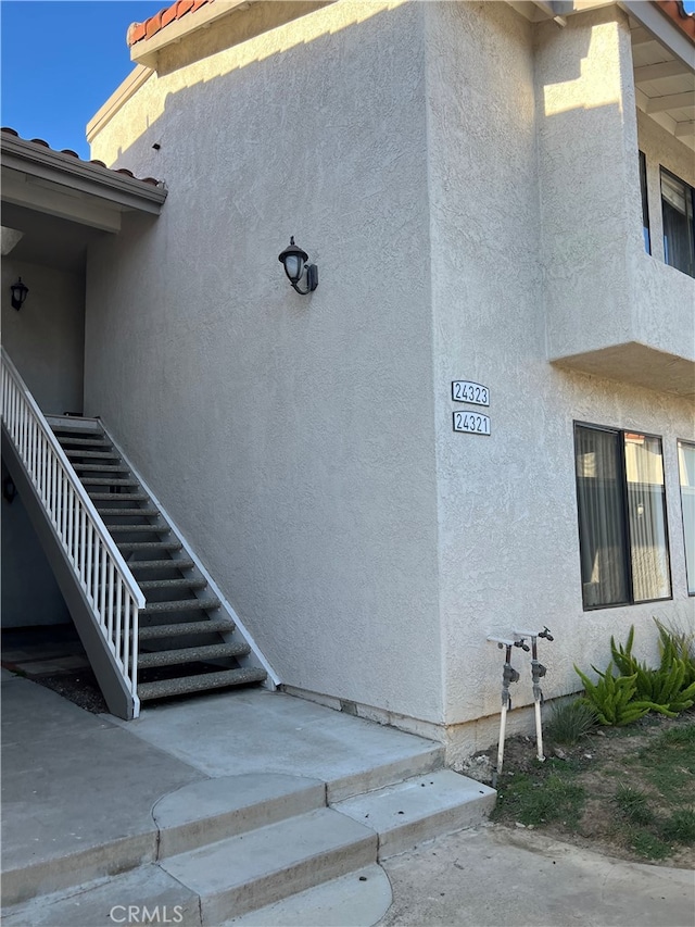 24321 El Pilar Unit 11, Laguna Niguel, CA 92677 - view of side of home with stucco siding, stairs, and a tiled roof