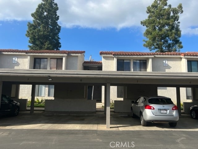 24321 El Pilar Unit 11, Laguna Niguel, CA 92677 - view of front of house with stucco siding, covered parking, and a tile roof