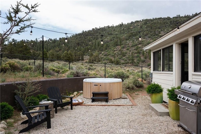 2000 Baldwin Lake Rd, Big Bear City, CA 92314 - view of patio with a hot tub, a view of trees, and a grill